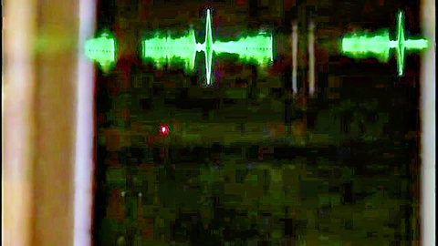 Abstract green audio waveforms on dark background from Kaloz Radio video