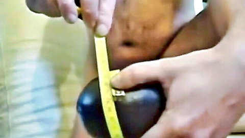 Hairy black man measuring thick black dildo for intense anal fisting