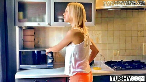 Blonde babe in sheer white tank top and tight orange shorts teasing in kitchen by microwave