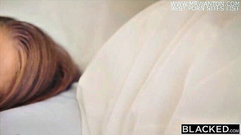 Redhead beauty lying seductively on white sheets in intense porn scene