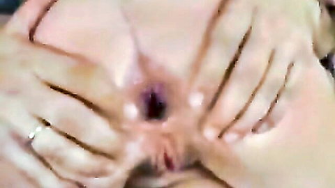 Close-up of woman's spread pink pussy and anus, hands parting for anal tease