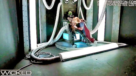 Blonde Supergirl cosplay straddles green alien monster in sci-fi throne cowgirl pose
