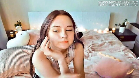 Cute Asian teen resting chin on hand, seductive gaze seeking daddy