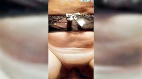 Close-up of mature woman's shaved pussy exposed through black lace panties with bow pulled aside