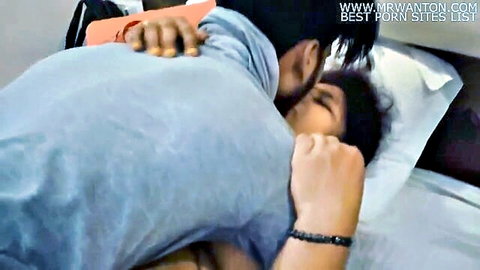 Passionate South Asian man kissing and groping Indian woman's tits in bed