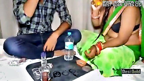 Desi Indian babe in green sari and black bra sits with boyfriend surrounded by water bottles