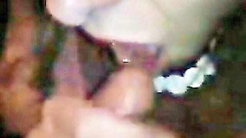 Closeup of woman's open mouth with pierced tongue covered in thick cum dripping from lips and cock tip