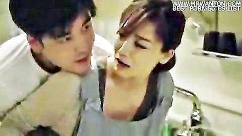 Korean MILF in apron seduced by son's friend in intimate kitchen embrace
