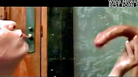 Closeup of slut puckering lips to suck thick glistening cock held by her hand