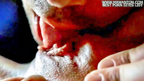 Man's open mouth and tongue devouring wet pink pussy in close-up cunnilingus.