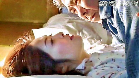 Older Japanese man passionately kissing young Asian beauty's lips in bed