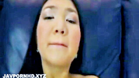 Closeup of sexy Asian woman's face with parted lips and sultry eyes on blue sheets
