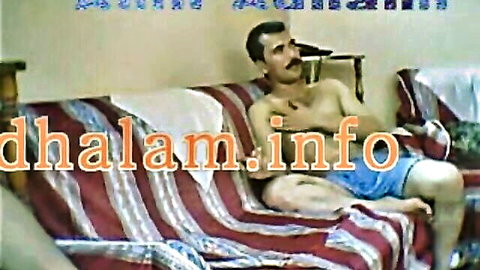 Egyptian man lounging shirtless in orange shorts, solo amateur tease