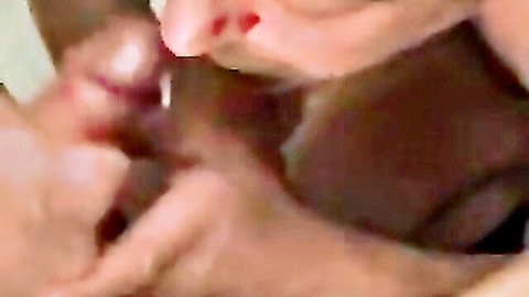 Close-up of busty woman with red lips sucking thick black cock deep in her mouth