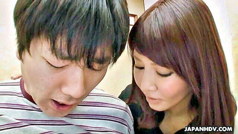 Japanese long-haired brunette passionately kissing young handsome guy close-up