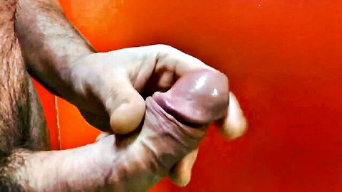 Hairy man stroking erect penis in solo masturbation close-up