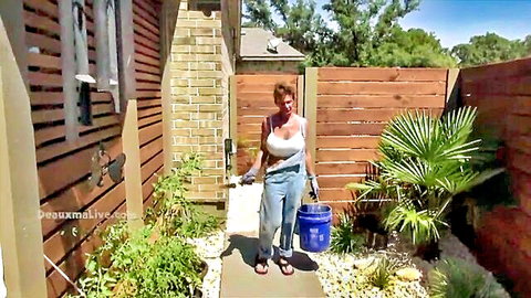Busty mature redhead MILF in revealing overalls with huge tits holding bucket outdoors
