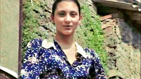 Penelope as vintage maid in floral dress, smiling, 1996 restored film
