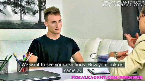 Female agent with glasses interviews skinny blonde guy in casting couch office scene