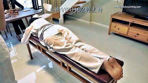 Chinese woman prone in white outfit for intense BDSM spanking