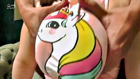 Bearded man holds unicorn plush over busty woman's chest in Japanese BDSM tease