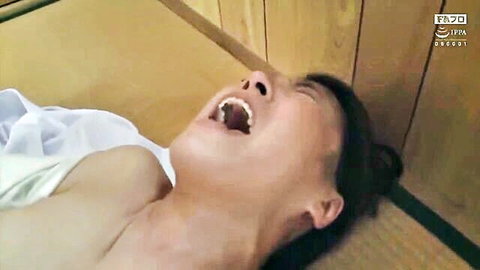 Japanese MILF lying on tatami floor with big tits exposed and mouth wide open in ecstasy