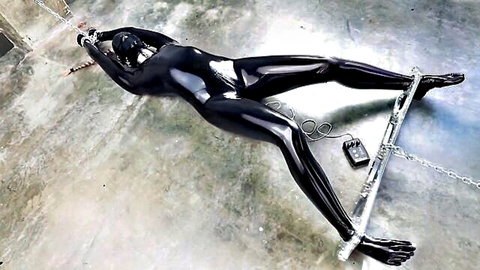 Shiny latex-clad woman bound spread-eagle in chains and spreader bar with electro play wires