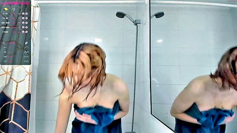 Wet redhead covering natural tits with blue towel in steamy shower mirror selfie