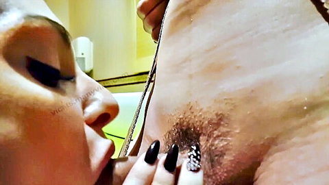 Brunette amateur sucking hairy cock base in bathroom with black nails gripping shaft