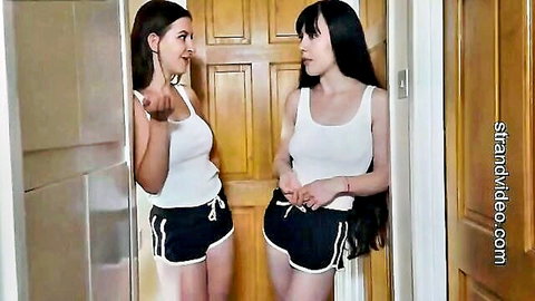 Two slim women in white tanks and black shorts in BDSM spanking bet scene