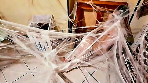 Woman bound in white spider webs for intense BDSM bondage session