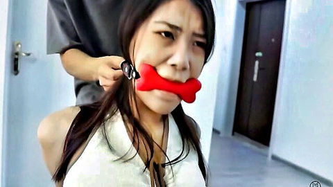 Asian woman hogtied and bone-gagged in intense BDSM bondage