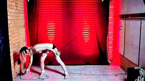 Pink-haired slim woman nude in self-bondage, cuffed wrists and ankles with chains