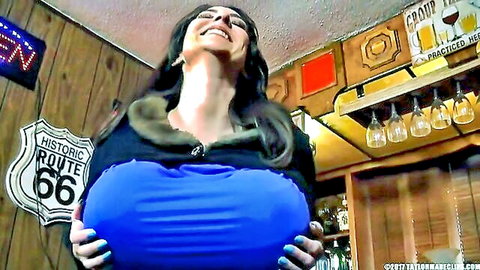 Brunette MILF with glasses smiles while cupping her massive blue tits in Route 66 bar