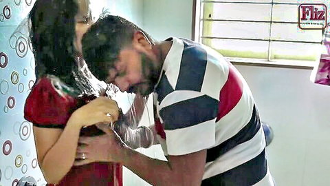 Indian darkhaired babe in red dress with man sucking her exposed tits in amateur porn