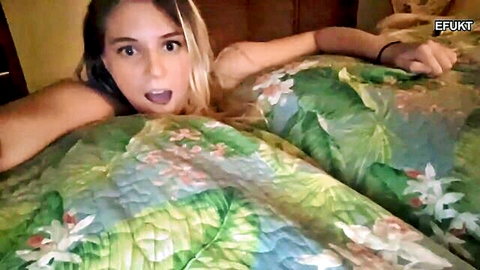 Surprised blonde woman topless on bed in amateur video