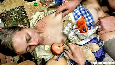 Pale brunette cradling doll with exposed breasts groped in twisted family horror scene