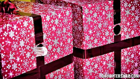 Hand peeking out from pink Christmas present box teasing naughty surprises