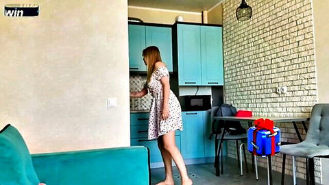 Blonde stepmom in short floral dress bending over with gift