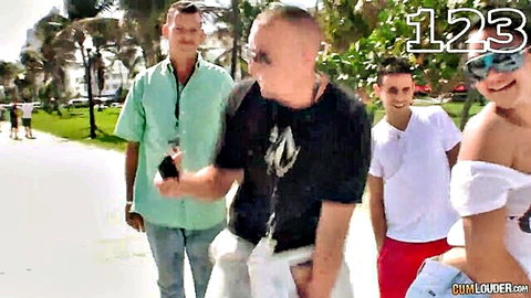 Smiling Latina woman with big ass walks beach path with shirtless couple and friends in casual summer clothes