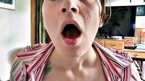 POV closeup amateur woman wide open mouth shocked eyes striped shirt