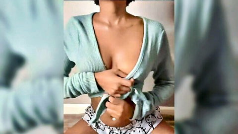 Ebony woman teasing with exposed perky tits in open cardigan and shorts