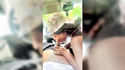 Ebony woman in floral hat sucking cock in car backseat