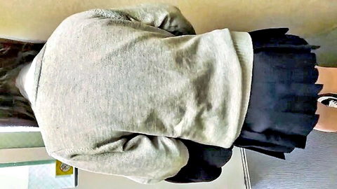 Cute Japanese girl in gray sweater and black pleated skirt, upskirt view from behind