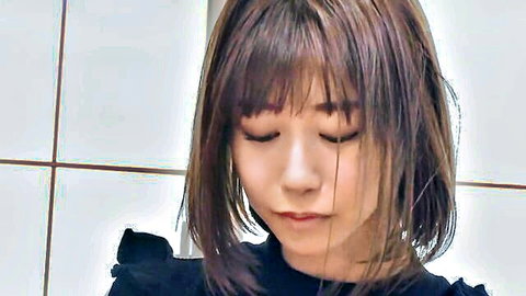 Japanese woman with bangs in black frilly top, sultry gaze for group sex tease