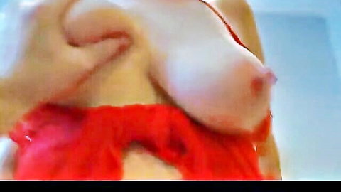 Busty woman in red lingerie squeezing exposed breasts