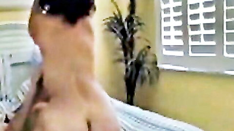 Mature brunette bends over naked showing pierced nipple and round ass in amateur bedroom