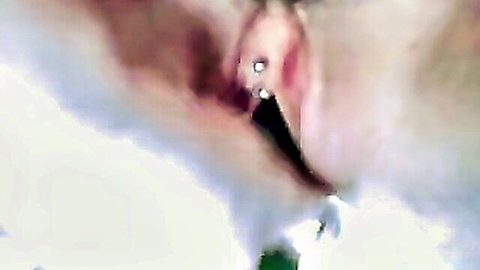 Blurry close-up of pierced pussy with cucumber insertion