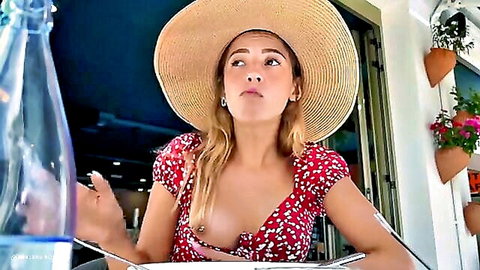Blonde woman in revealing red floral dress showing deep cleavage outdoors