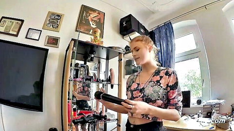 Blonde Lucy Live holds black dildo in sexy floral crop top